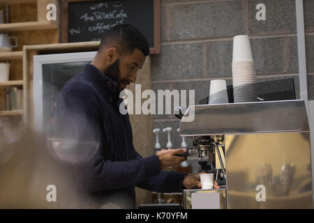 Side view of male owner making coffee in cafe Stock Photo