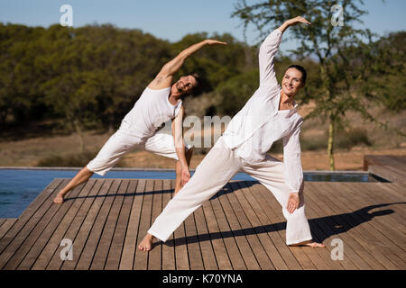 Couple performing yoga at safari vacation on a sunny day Stock Photo