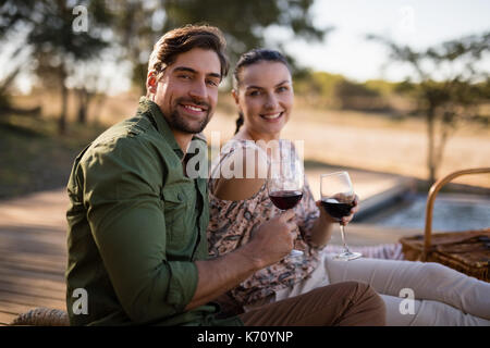 Portrait of couple having red wine during safari vacation Stock Photo