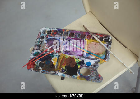 Paintbrushes on palette in art studio Stock Photo