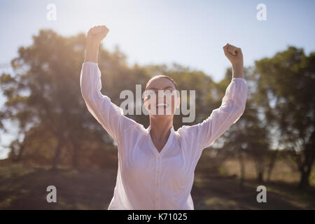 Happy woman standing with arms up during safari vacation Stock Photo