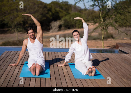 Couple performing yoga at safari vacation on a sunny day Stock Photo