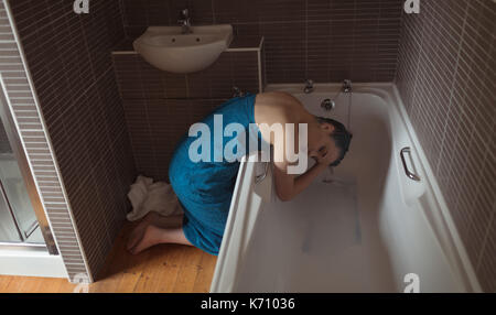 Side view full length of young woman washing hair in bathtub at bathroom Stock Photo