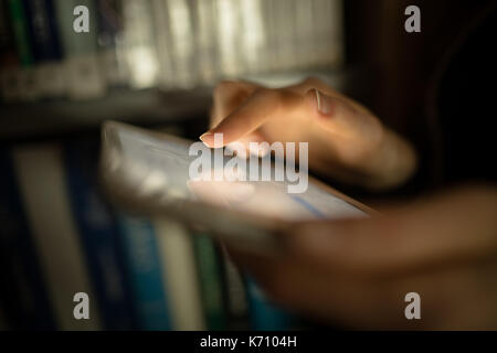 Close-up of woman using digital tablet in library room Stock Photo