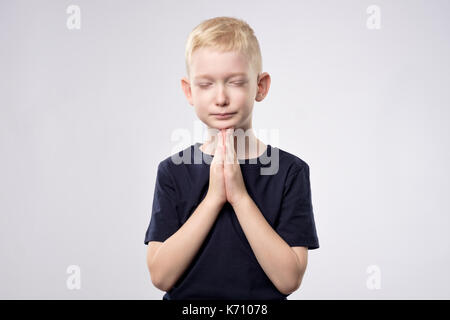 Little caucasian boy with blond hair praying Stock Photo