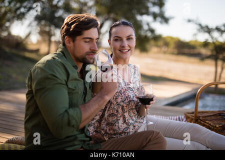 Romantic couple drinking red wine during safari vacation Stock Photo
