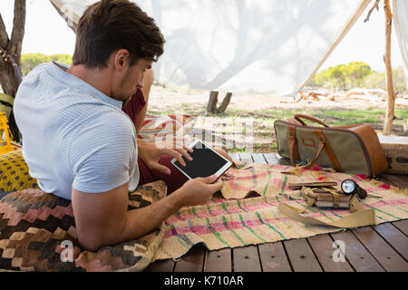 Relaxed young man using digital tablet in tent Stock Photo