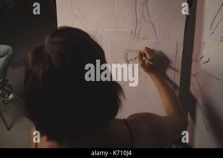 Artist drawing sketch on canvas in studio Stock Photo