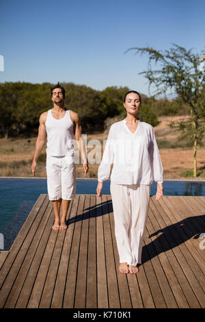 Couple performing yoga at safari vacation on a sunny day Stock Photo