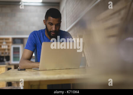 Young man using laptop while sitting in coffee shop Stock Photo