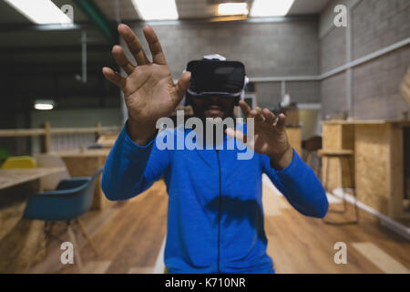Man looking through virtual reality simulator while sitting in cafeteria Stock Photo