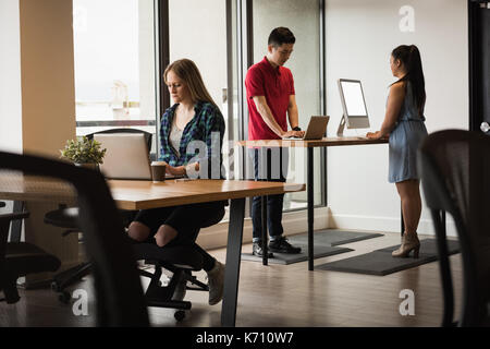 Business people using technologies at table in creative office Stock Photo