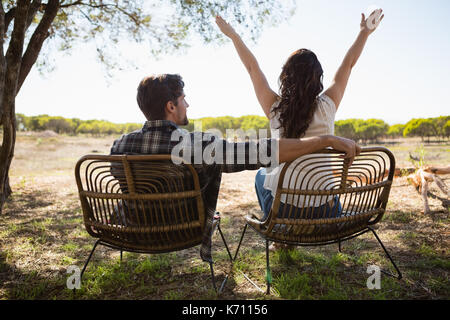 Rear view of a man and a woman sitting on the beach, South Beach, Miami ...