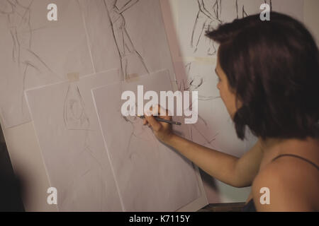 Artist drawing sketch on canvas in studio Stock Photo