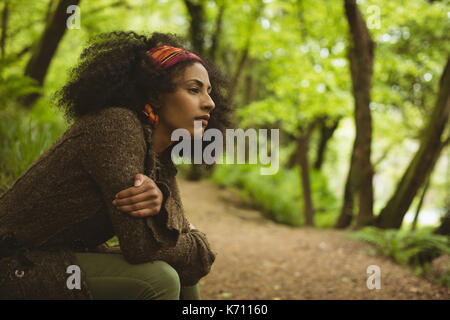Side view of thoughtful young woman looking away at forest Stock Photo