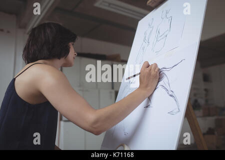 Artist drawing sketch on canvas in studio Stock Photo