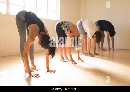 Yoga instructor with students exercising in yoga studio Stock Photo