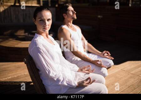Couple performing yoga at safari vacation on a sunny day Stock Photo