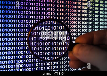 Binary code, Password security, hand holding magnifying glass showing exploit Stock Photo