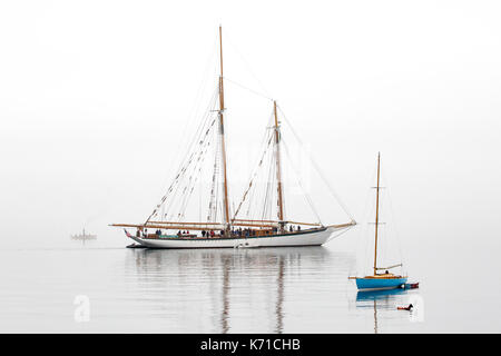 Sailing boat, sailboat wooden schooner yacht Port Townsend, Puget Sound, Washington. Sailing boat  Zodiac in fog. Stock Photo