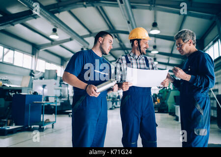 Engineer Teaching Apprentices To Use Computerized cnc metal processing machines Stock Photo