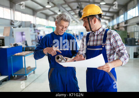 Engineer Teaching Apprentices To Use Computerized cnc metal processing machines Stock Photo