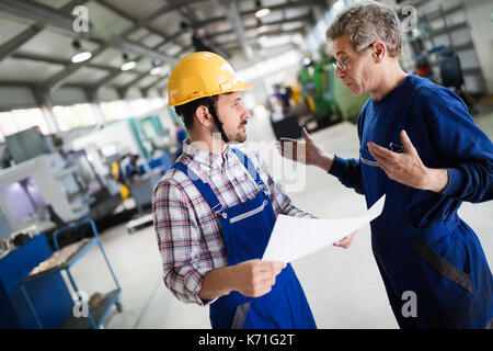 Engineer Teaching Apprentices To Use Computerized cnc metal processing machines Stock Photo