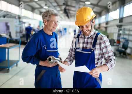 Engineer Teaching Apprentices To Use Computerized cnc metal processing machines Stock Photo