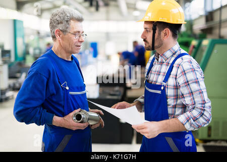 Team Of Engineers Having Discussion In Factory Stock Photo