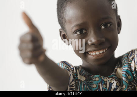 Handsome young African boy showing his thumbs up as a success symbol, isolated on white Stock Photo