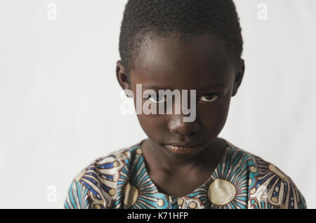 Young African boy showing his angry face, isolated on white< Stock Photo