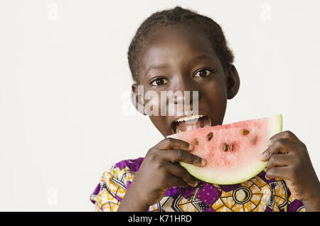 Young African girl eating some watermelon, isolated on white Stock Photo