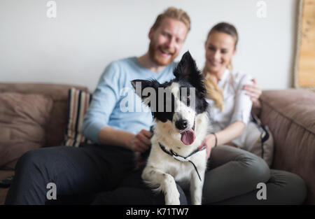 Beautiful couple relaxing at home and loving their dog Stock Photo