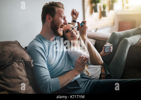 Romantic couple eating ice cream together and watching tv Stock Photo