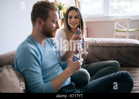 Romantic couple eating ice cream together and watching tv Stock Photo