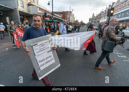 London, UK. 14th September 2017. Campaigners from 'Stop Killing Londoners' wlak on to the crossing at Brixton Underground station blocking the road for a second short period in a protest against London's excessive air pollution, due mainly to traffic. The air on the Brixton Road breaches the annual pollution limit in only 5 days, roughly 70 times the limit per year. Toxic air pollution results in 10,000 premature deaths in London each year and is particularly harmful to the elderly and the very young. To cut the disruption to traffic they moved out of the road after around five minutes, allowe Stock Photo