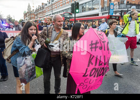 London, UK. 14th September 2017. Campaigners from 'Stop Killing Londoners' stand on the crossing at Brixton Underground station blocking the road in a protest against London's excessive air pollution, due mainly to traffic. The air on the Brixton Road breaches the annual pollution limit in only 5 days, roughly 70 times the limit per year. Toxic air pollution results in 10,000 premature deaths in London each year and is particularly harmful to the elderly and the very young. To cut the disruption to traffic they moved out of the road after around five minutes, allowed the traffic build up to mo Stock Photo