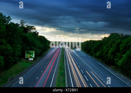 Late evening traffic on the A47 dual carriageway between Norwich and Great Yarmouth, showing the light trails from fast moving cars Stock Photo