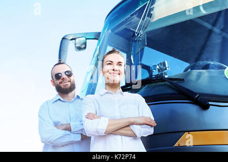 Transportation company, driver and tour operator .  The driver and tour guide are standing in front of the coach Stock Photo