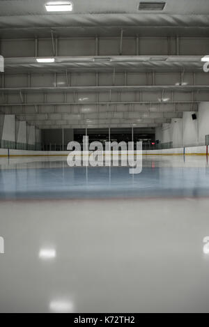 Illuminated empty ice hockey rink Stock Photo