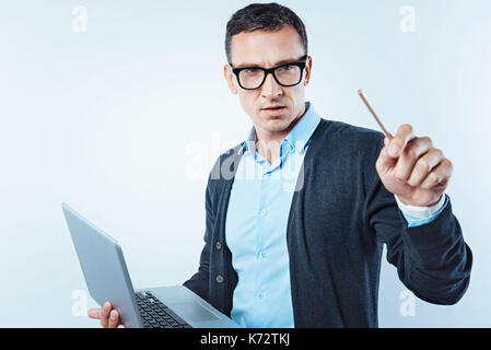 Pensive man pretending to touch invisible screen Stock Photo