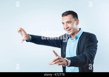 Positive minded guy pretending to touch invisible screen Stock Photo