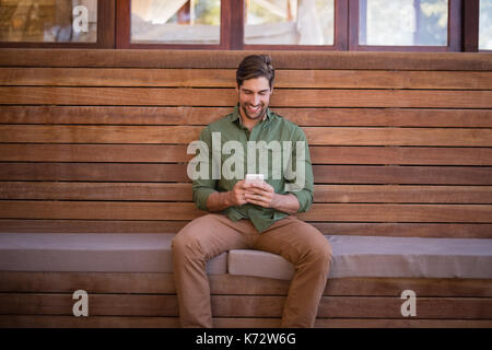 Happy man using mobile phone in cottage Stock Photo