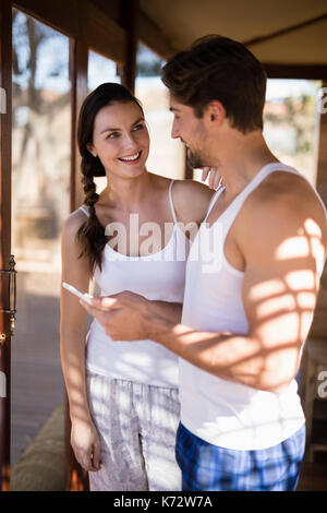 Happy couple using digital tablet in cottage during safari vacation Stock Photo