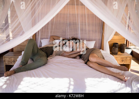 Couple sleeping on canopy bed during safari vacation Stock Photo