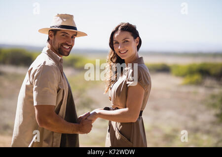 Portrait of smiling couple holding hands during safari vacation Stock Photo