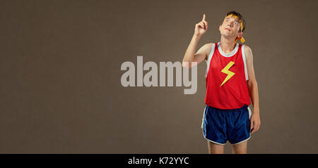 A thin funny guy in sports clothes shows his finger up.  Stock Photo