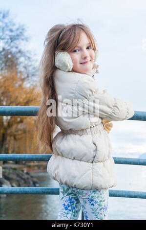 Winter portrait of cute little girl wearing white warm jacket Stock Photo