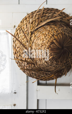 Texture of straw hat Bali style hanging on white wall close up Stock Photo