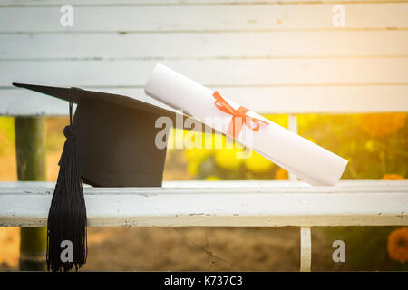 Graduation cap, Hat with degree paper on white wood table, abstract light background Empty ready for your product display or montage. Stock Photo